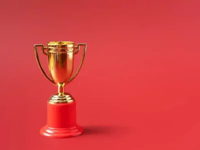Golden trophy on a red pedestal against a solid red background, symbolizing achievement and recognition in plumbing services.