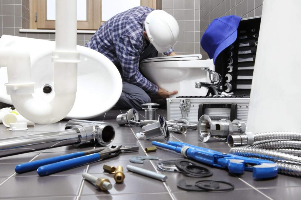 Best Plumber in Austin TX Plumber repairing a toilet with tools and plumbing parts in a bathroom setting, highlighting expert toilet repair services in Austin, TX.