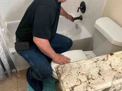 Plumber performing faucet repair in a bathroom setting, addressing plumbing issues related to faucet leaks and maintenance in Elgin, TX.